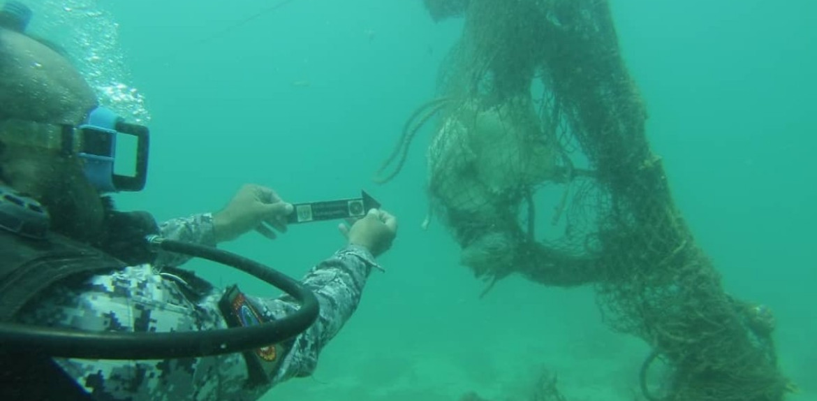 Pescadores encuentran un cadáver amarrado en una red en el fondo del mar.